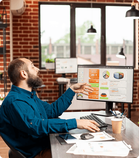Man cheering in front of computer monitor showing campaign analytics