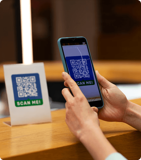 Person using smartphone to scan a QR code for payment