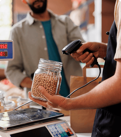 Operator using electronic barcode scanner and weighing scale