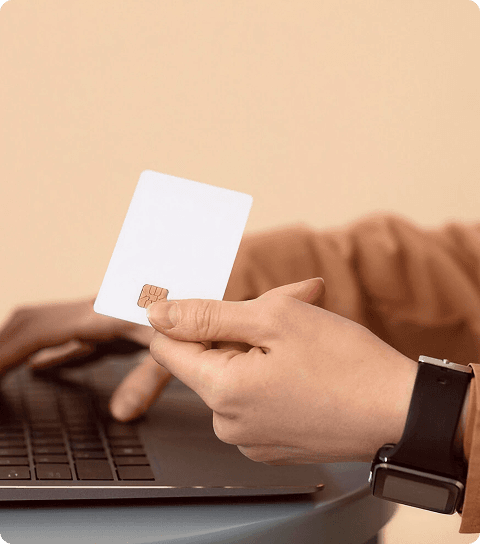 Person holding credit card near laptop
